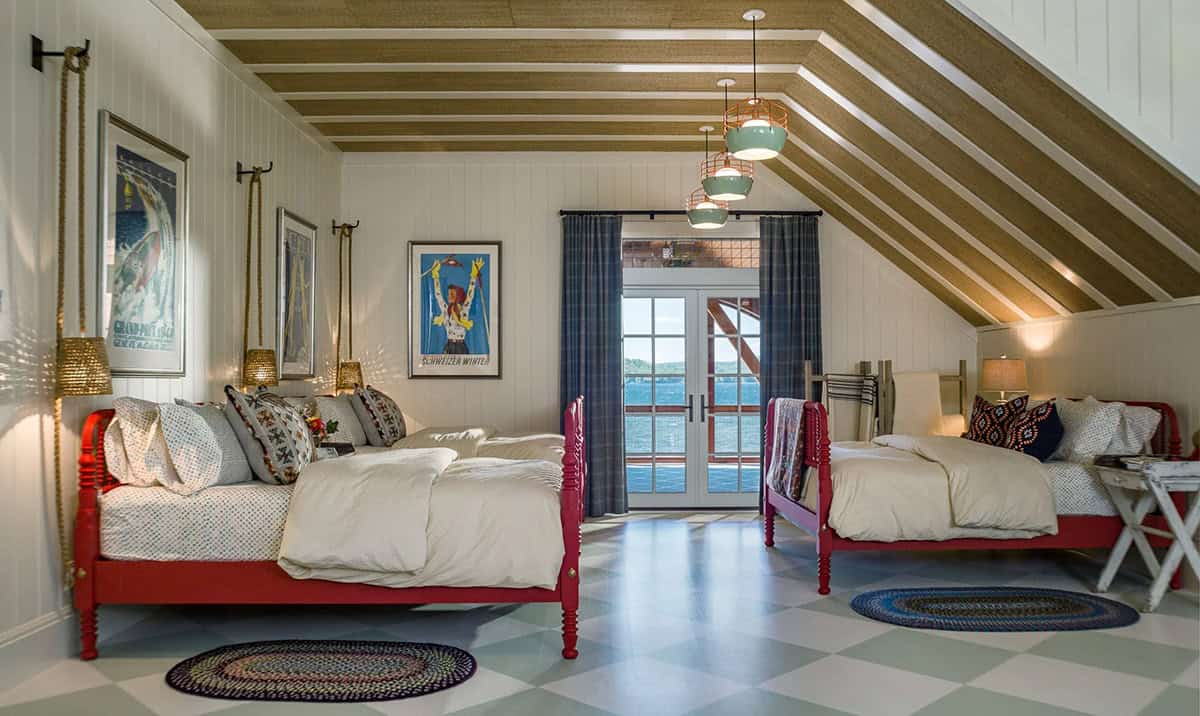 Guest bedroom in the Lake Sunapee summer house with traditional furnishings &mdash; an antique bed, painted wood walls, quilted coverlet, and windows overlooking the two-acre meadow