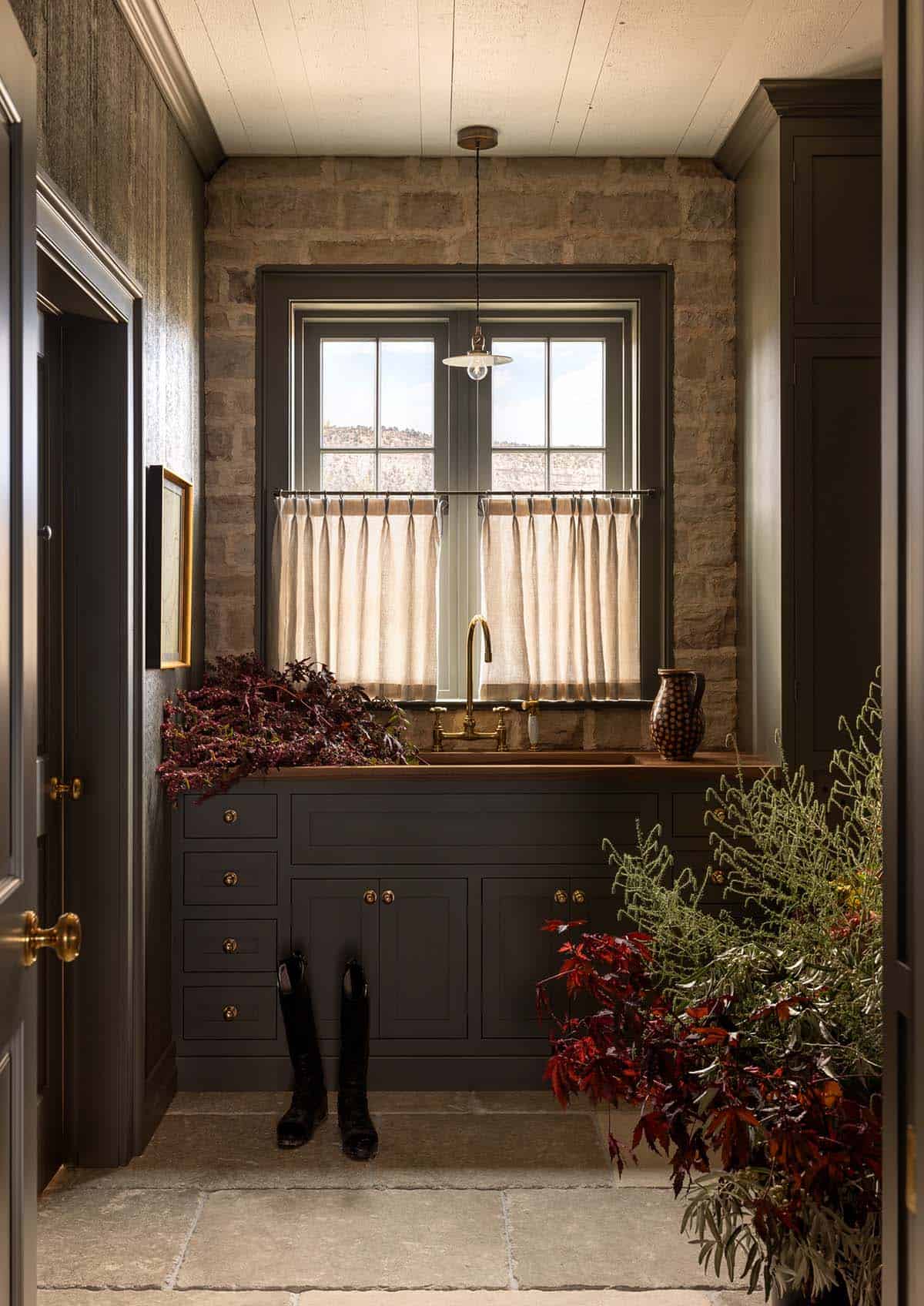 dark green mudroom with copper sink and riding boots, Colorado equestrian home