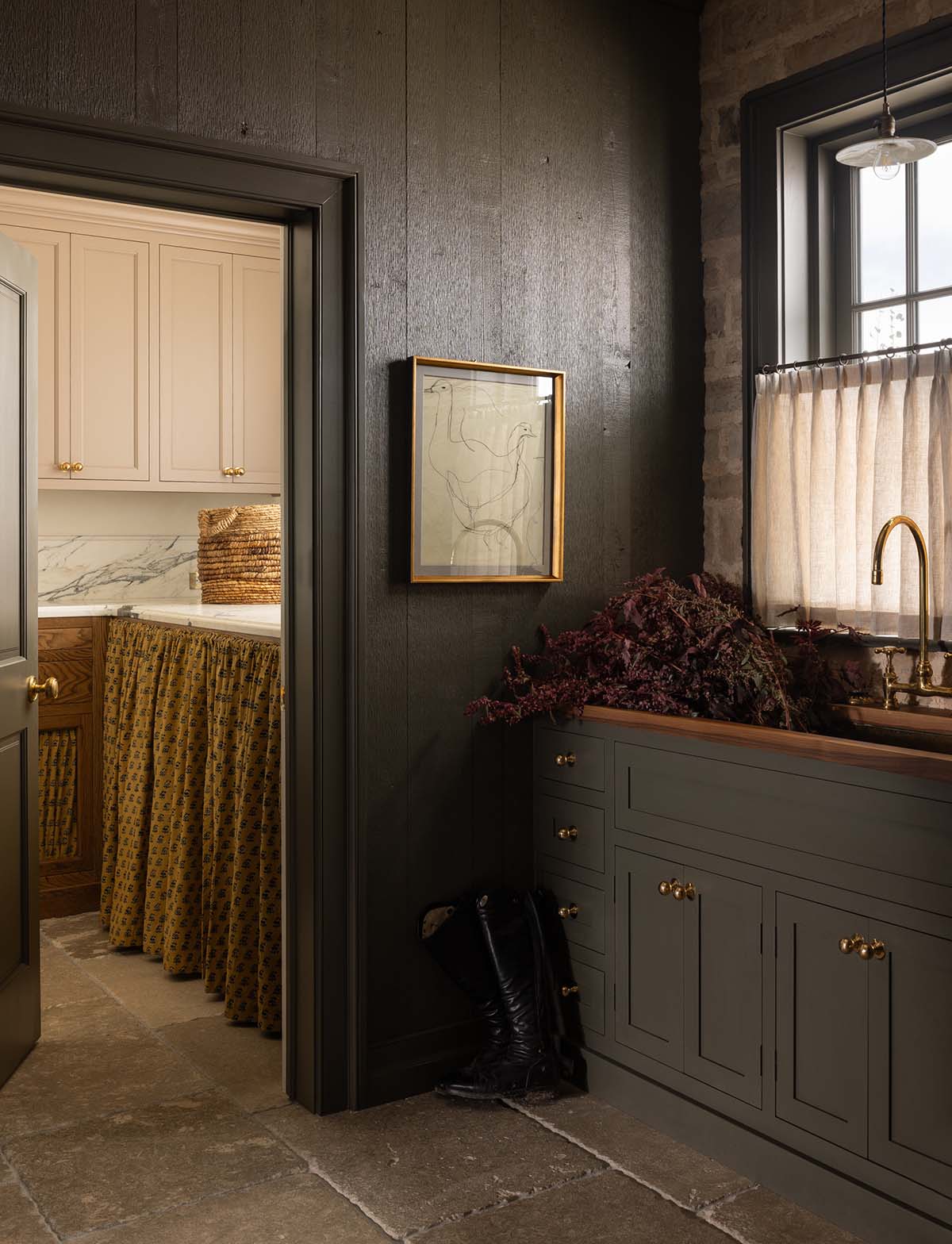 mudroom with dark plank walls and view into laundry room, Colorado equestrian home