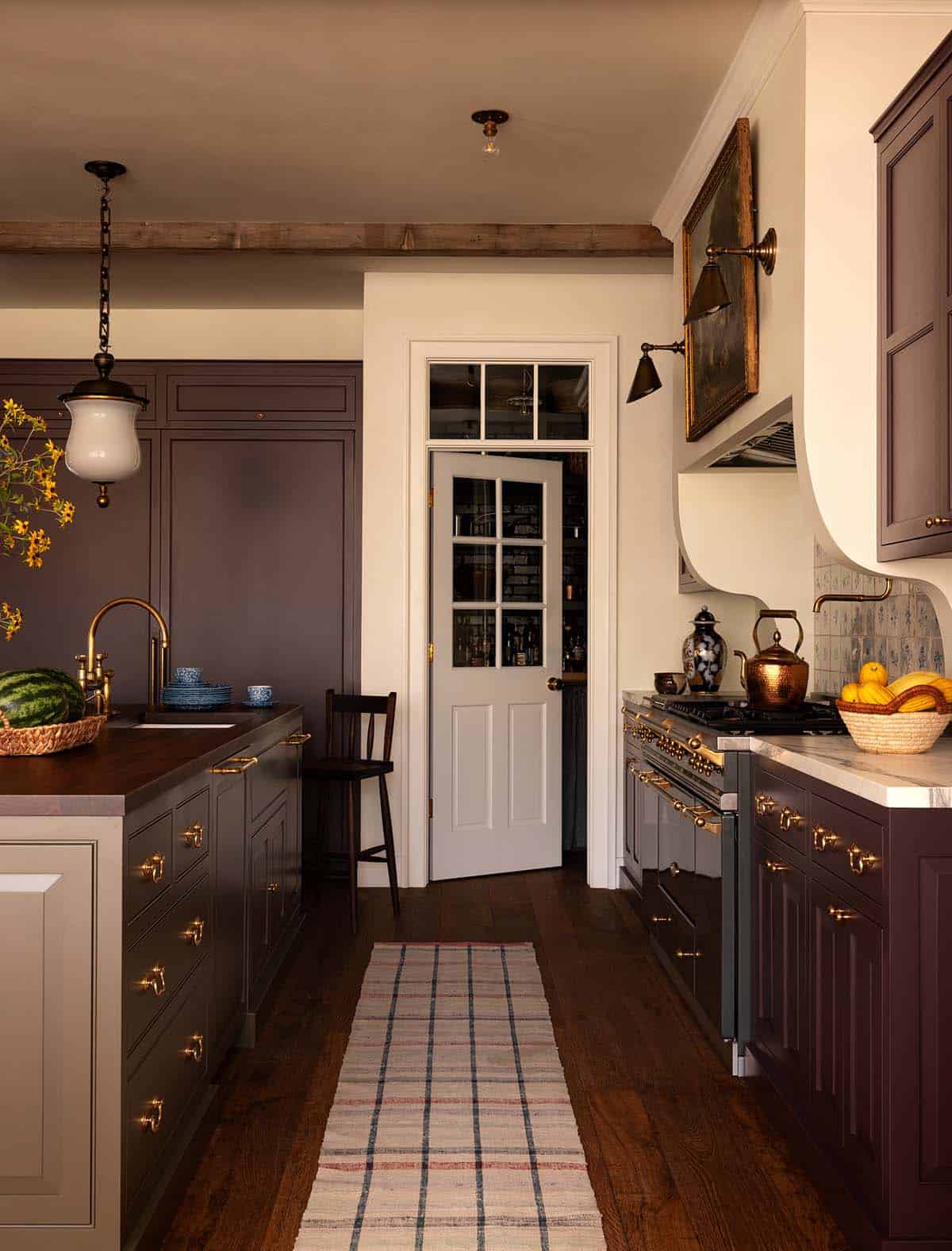 kitchen with plum cabinetry, brass hardware, and pantry door, Colorado equestrian home