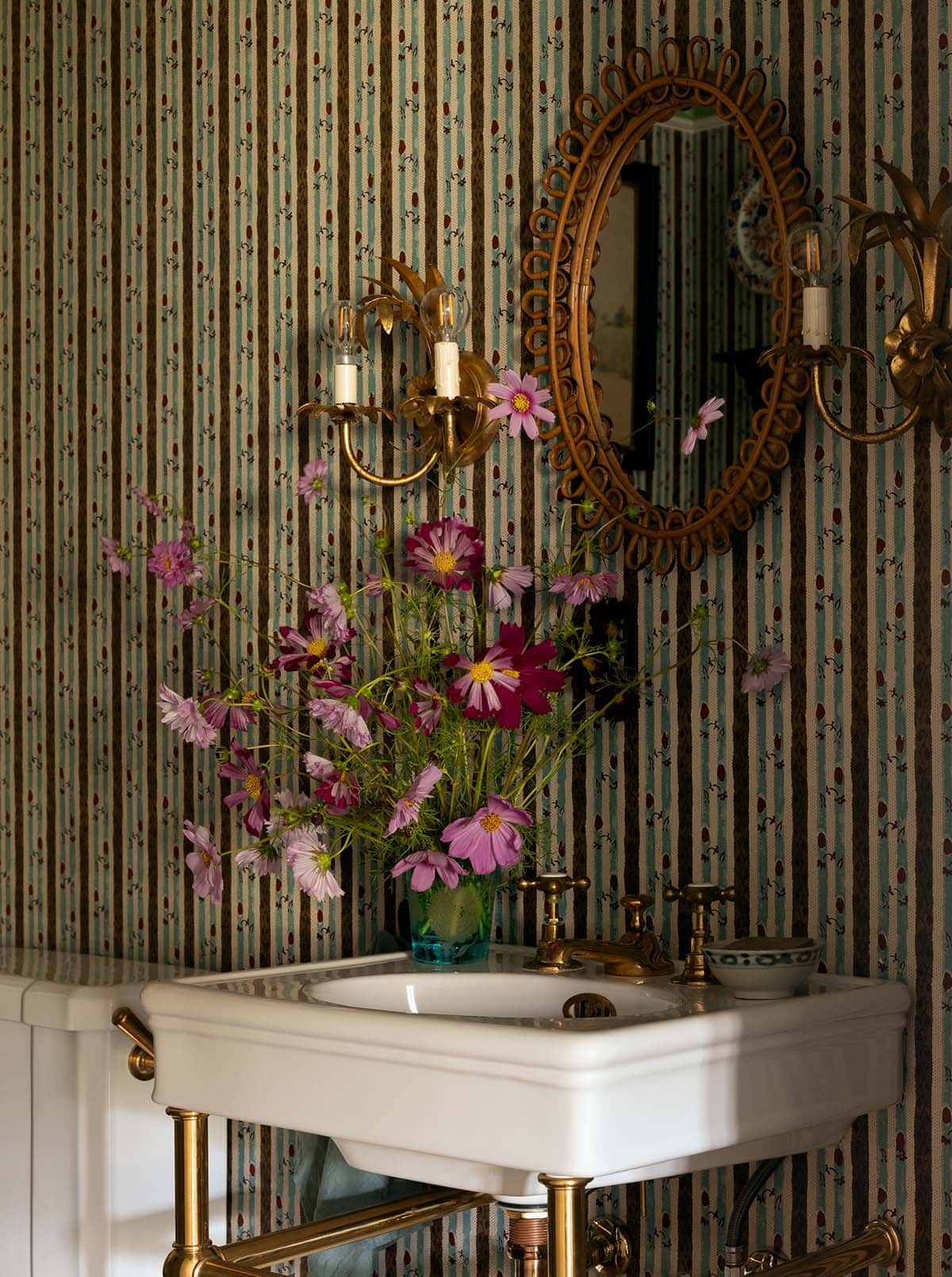 powder room sink detail with rattan mirror and brass sconces, Colorado equestrian home