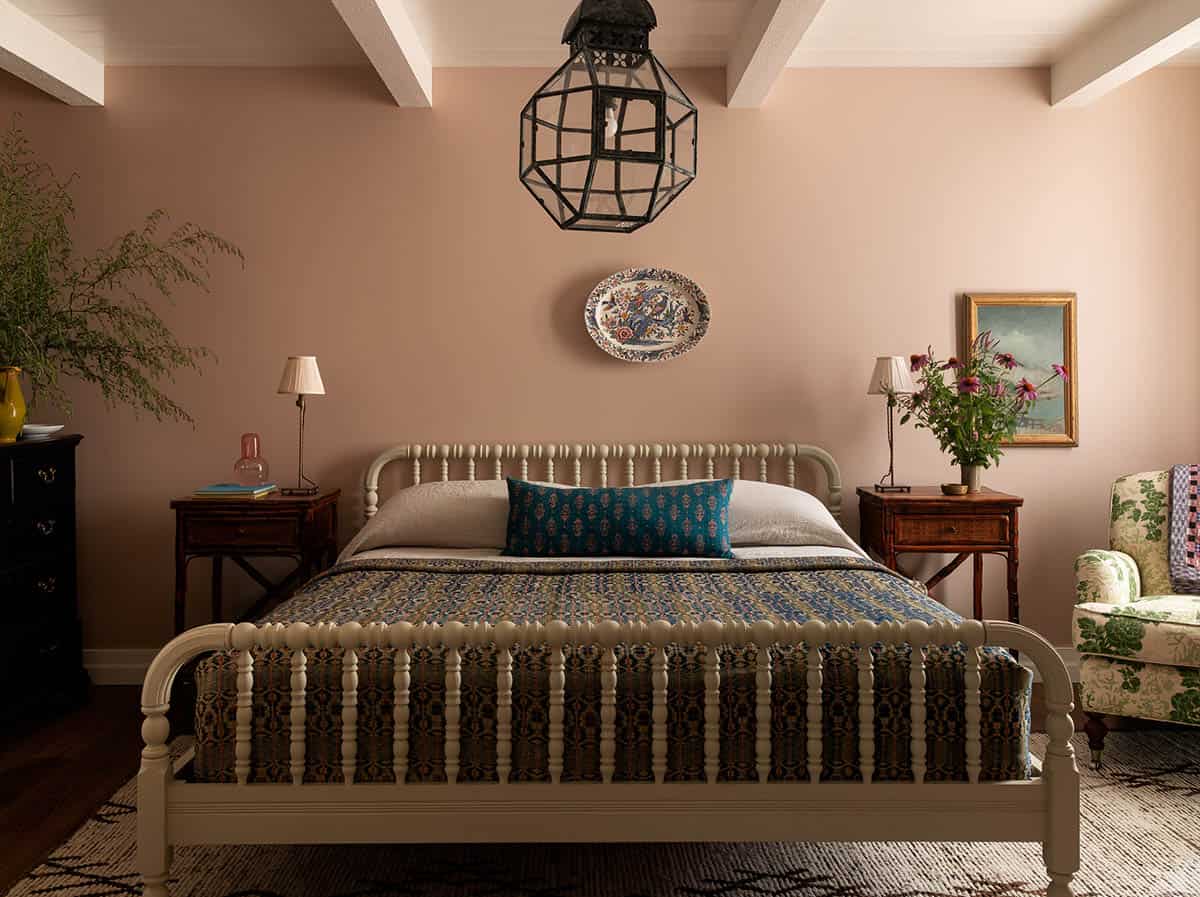 pink primary bedroom with spindle bed and antique lantern pendant, Colorado equestrian home