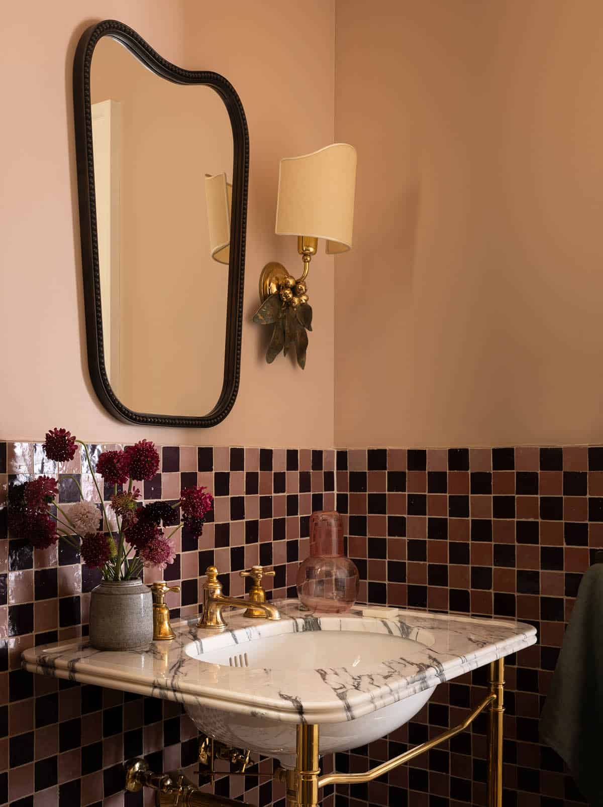 bathroom sink detail with marble vanity, checkered tile, and brass sconce, Colorado equestrian home