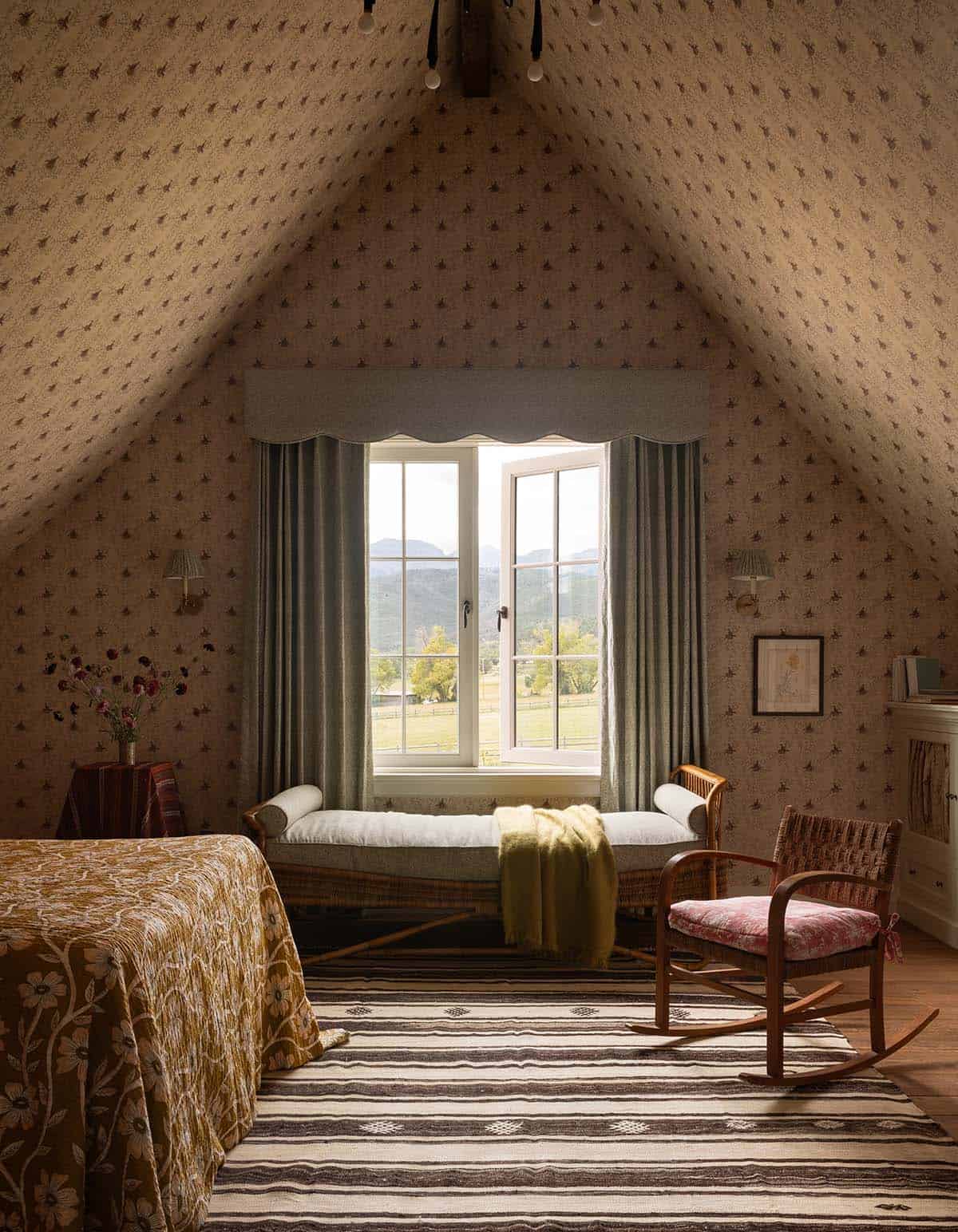 attic guest bedroom with vaulted wallpapered ceiling and mountain views, Colorado equestrian home