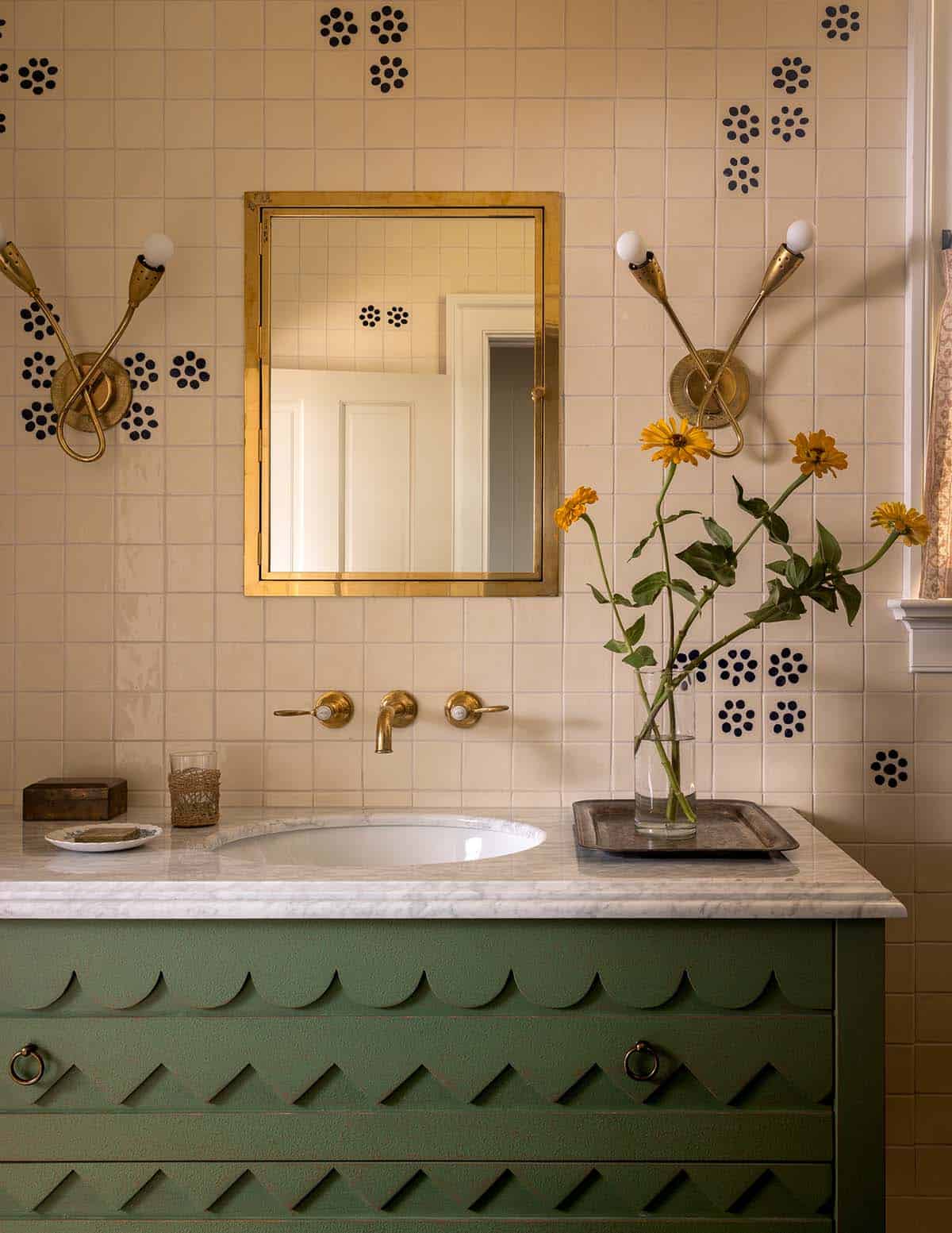 bathroom vanity detail with green scalloped cabinet, brass mirror, and patterned tile, Colorado equestrian home