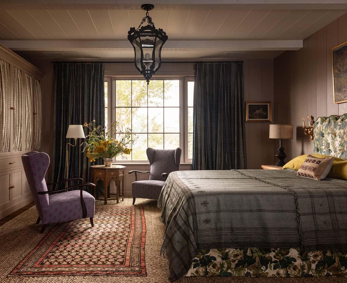 primary bedroom with floral headboard, dark velvet drapes, and antique lantern pendant, Colorado equestrian home