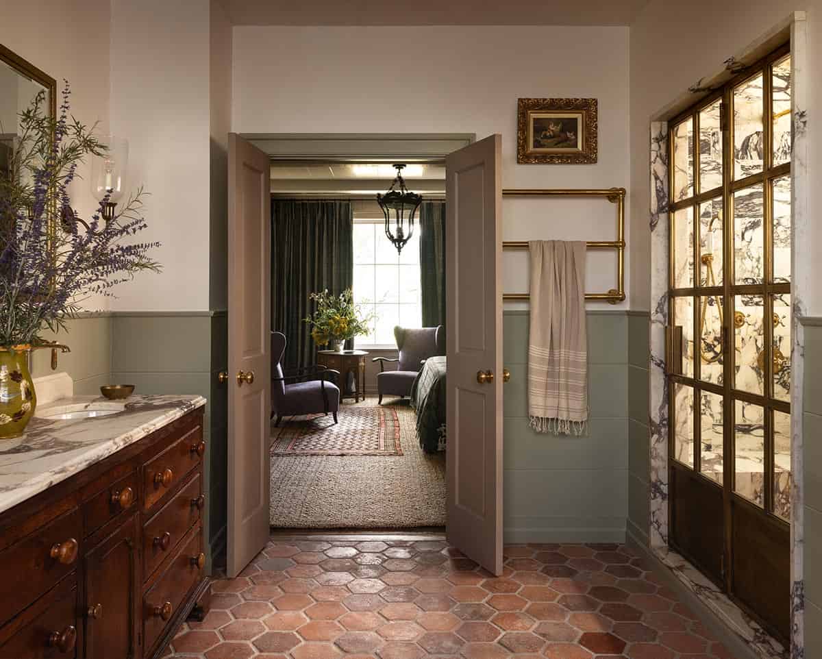 primary bathroom with terracotta hex tile floor, antique wood vanity, and marble shower, Colorado equestrian home