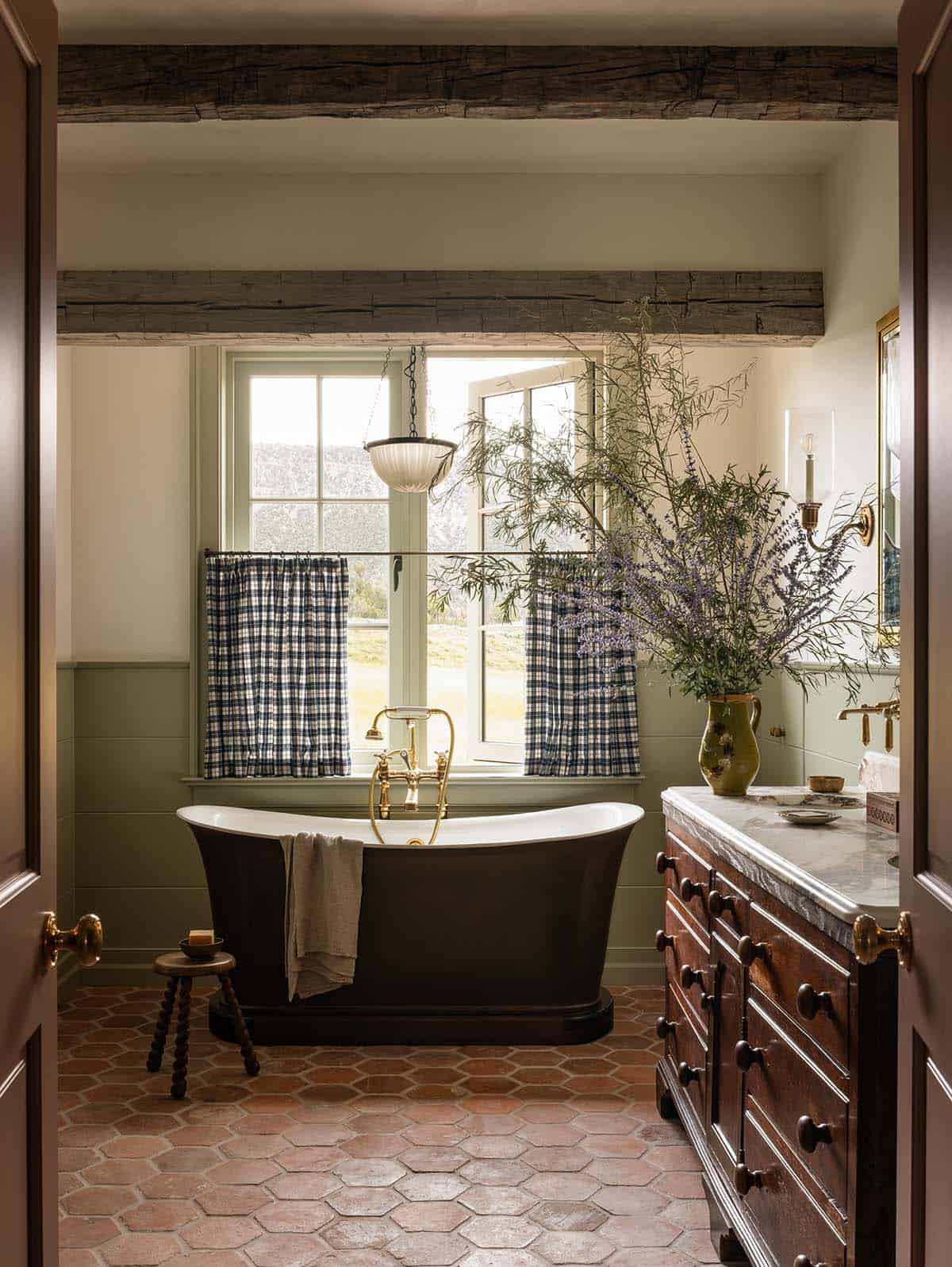 primary bathroom with black freestanding tub, terracotta hex tile, and mountain views, Colorado equestrian home
