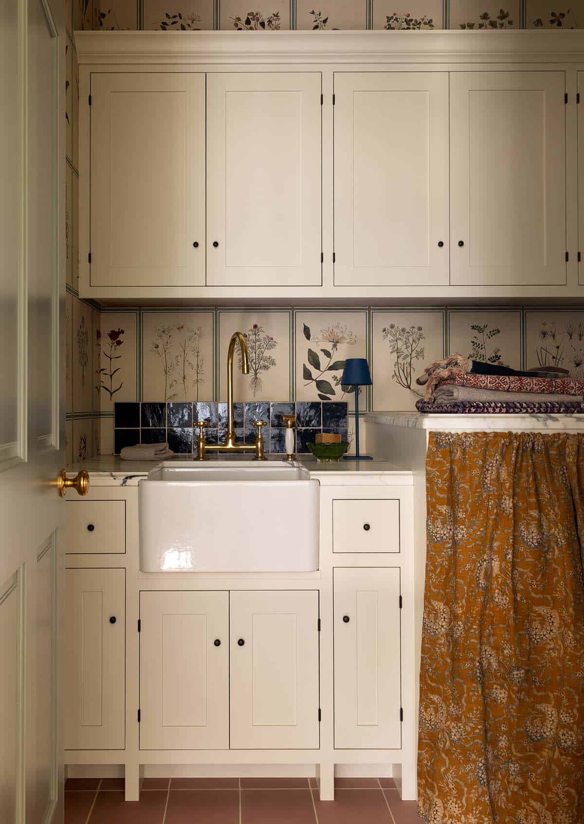 laundry room with cream cabinetry, farmhouse sink, and botanical wallpaper backsplash, Colorado equestrian home