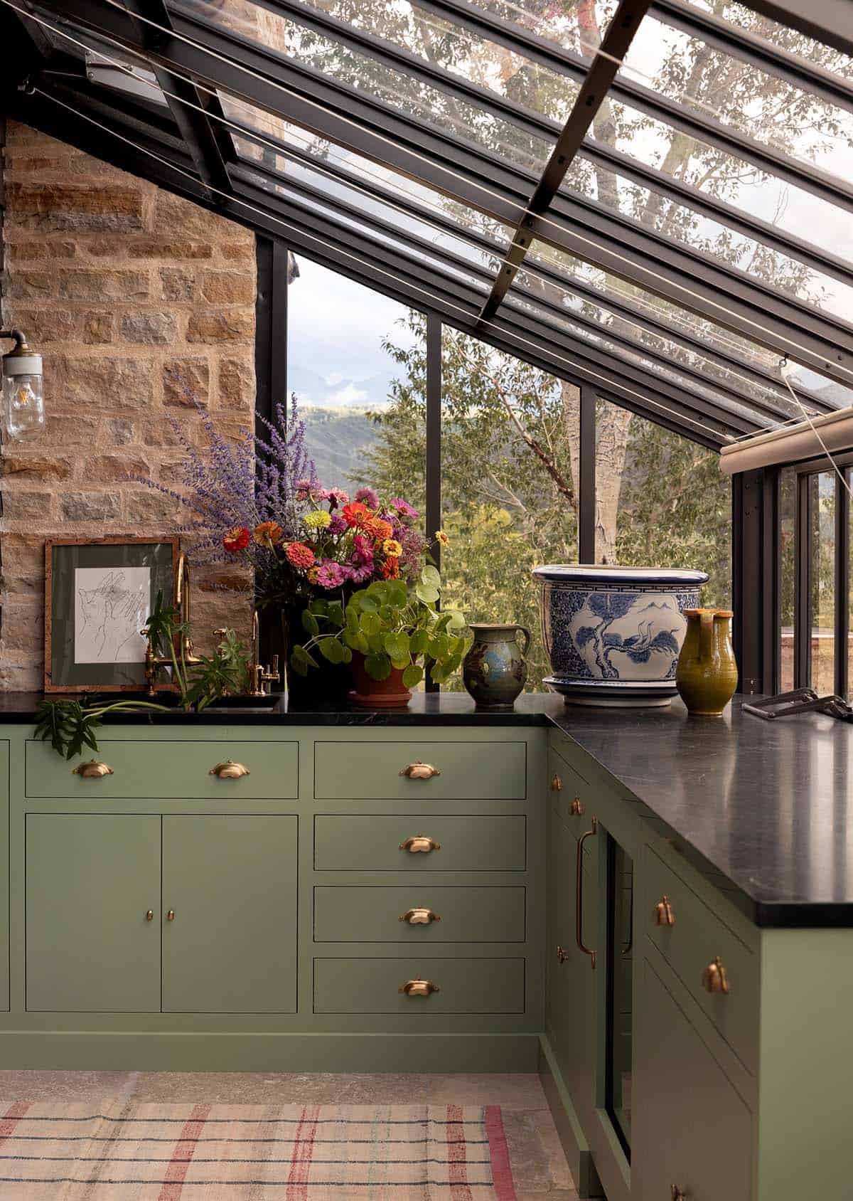 greenhouse potting room with sage green cabinetry, black countertops, and mountain views, Colorado equestrian home
