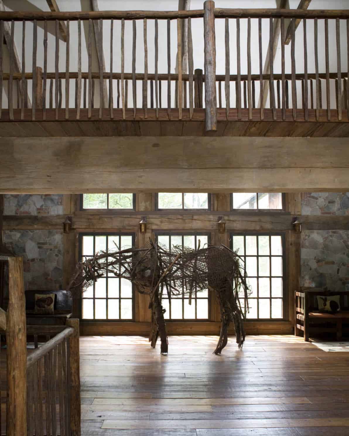 Life-size twig horse sculpture in great room with reclaimed wood balcony and plank floors