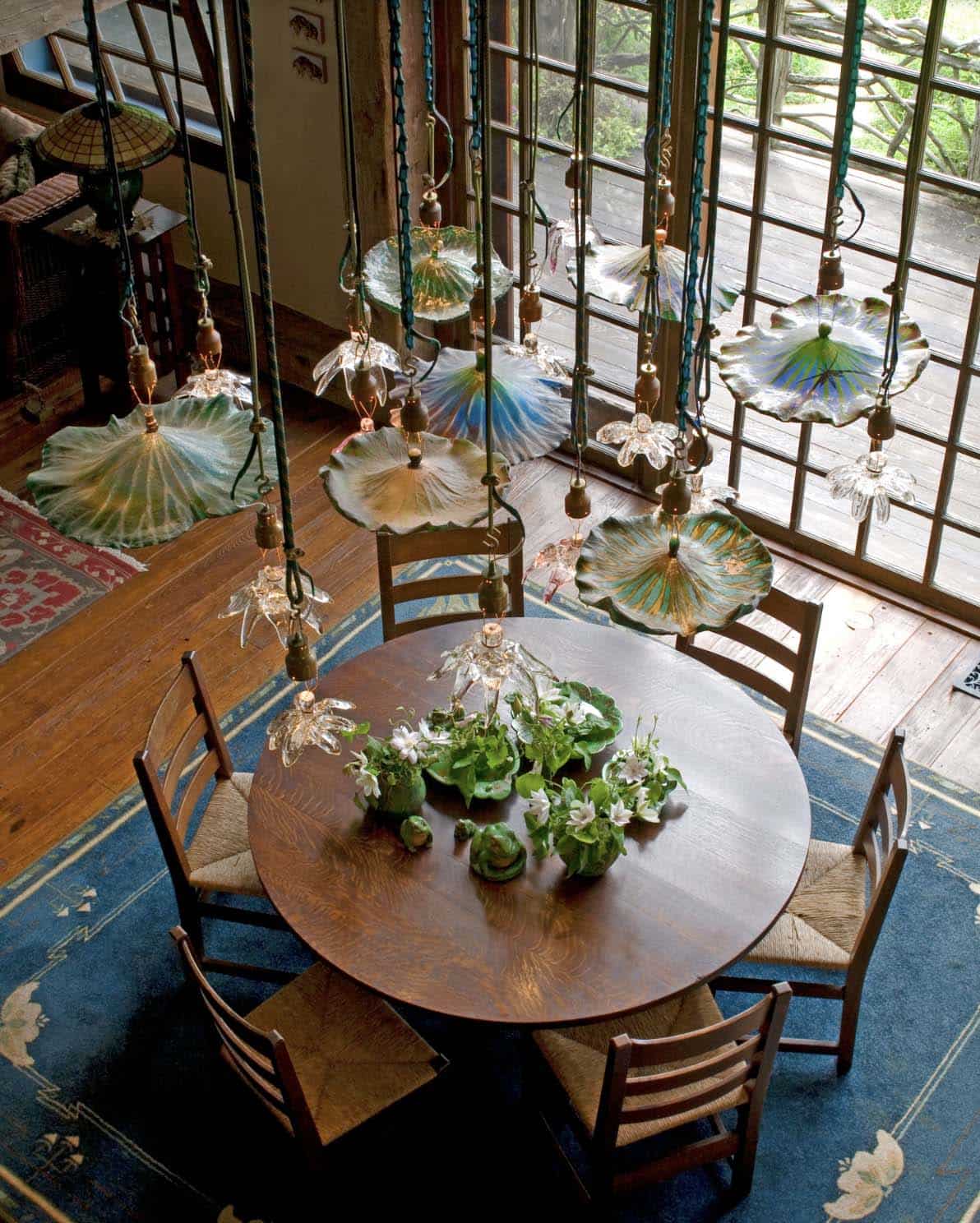 Aerial view of round dining table with colorful glass lily pad chandelier and rush-seat chairs