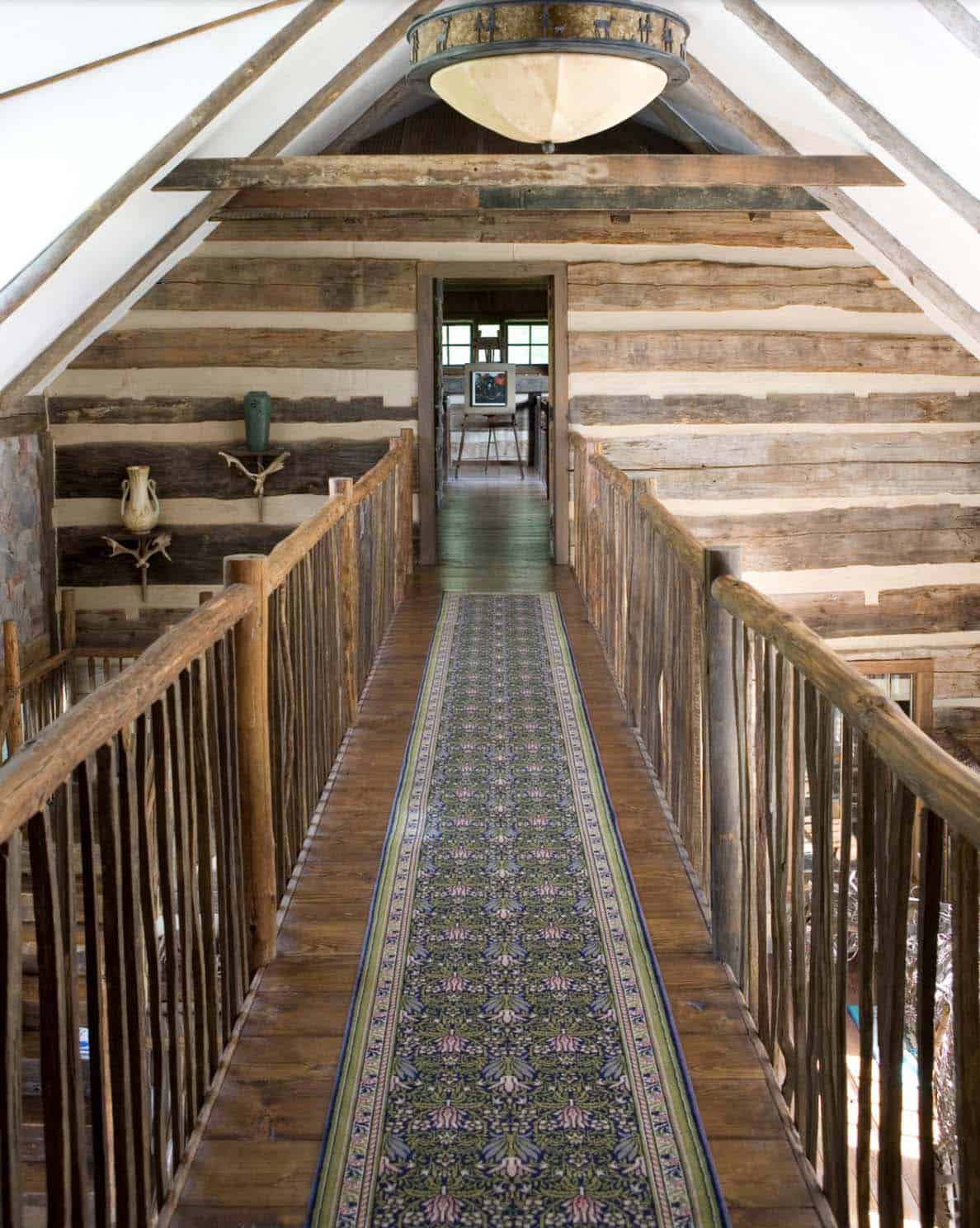 Upper hallway bridge with rustic log railings, William Morris runner, and vaulted ceiling
