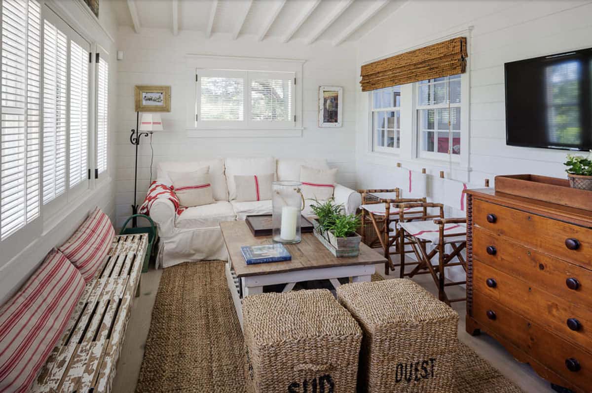 Guest cottage living room with slipcovered sofa, seagrass ottomans, bamboo chairs, and vintage wood dresser