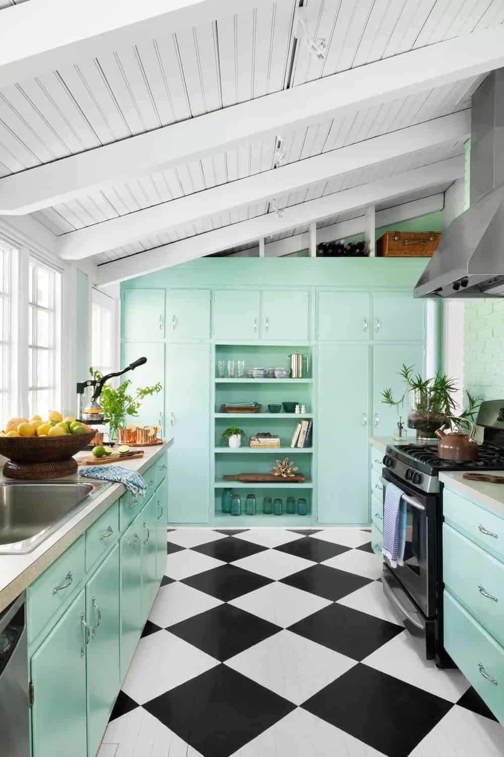 Retro kitchen with mint green metal cabinets, black and white checkerboard floor, and stainless countertops
