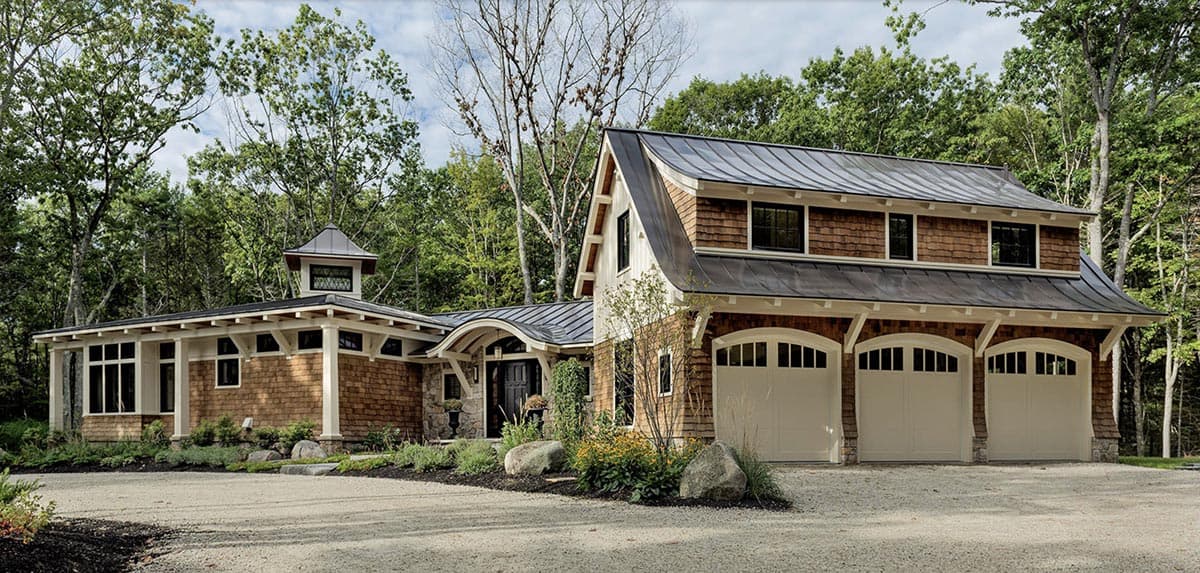 Cedar shingle and board-and-batten retreat with three-car garage and standing seam roof in York Maine woods