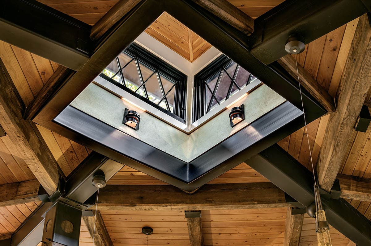 Upward view of dramatic natural light cupola with black steel frame and knotty pine ceiling surround