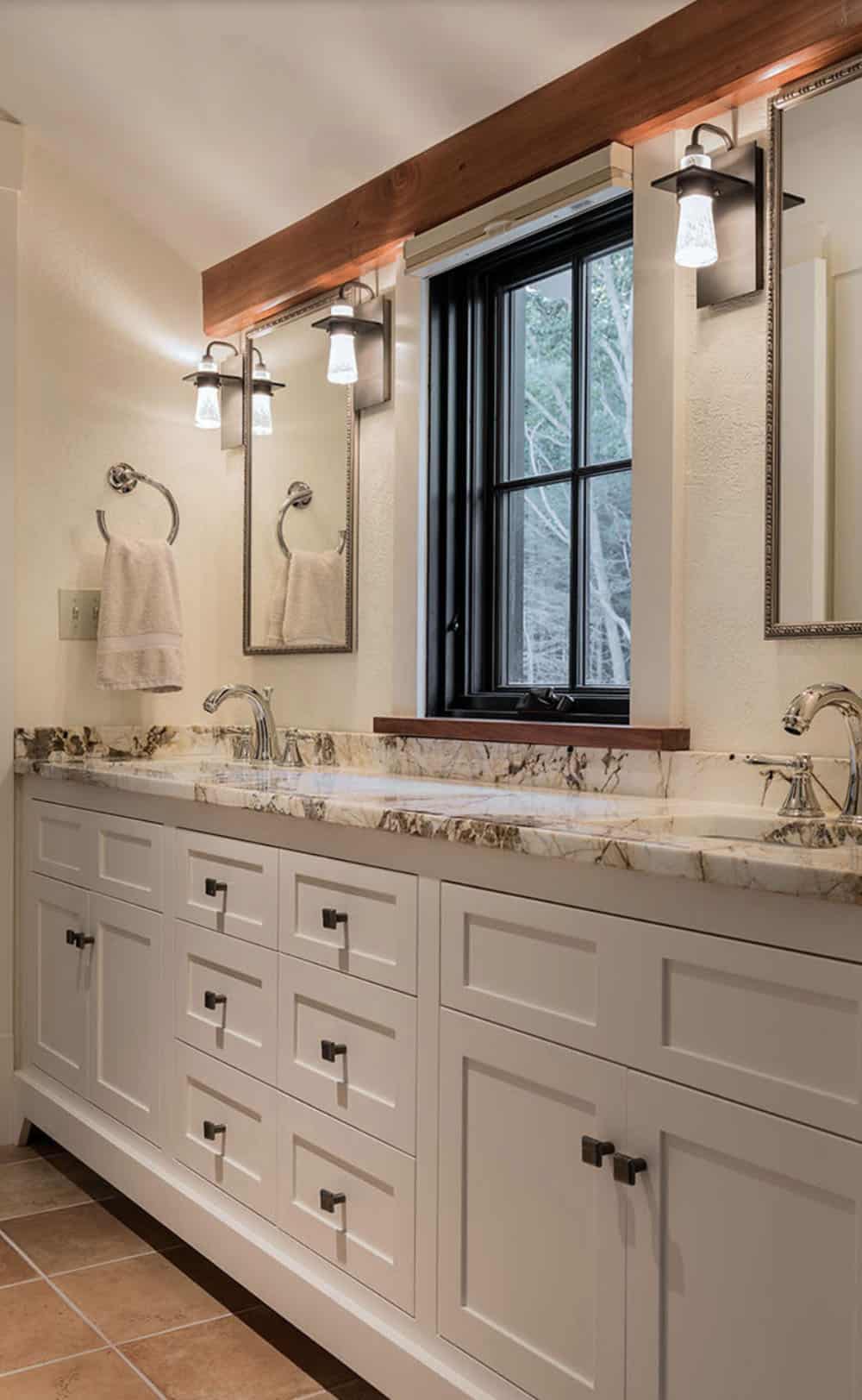 Guest bathroom with double white shaker vanity, dramatic veined marble countertop, and reclaimed timber beam above mirror
