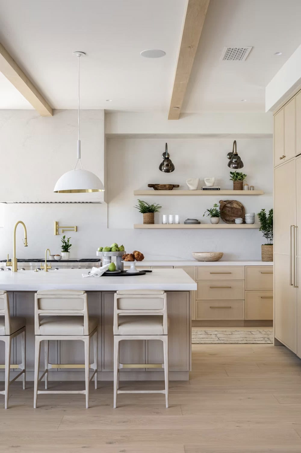 Kitchen detail with white dome pendant, open shelving, brass hardware, and sand-toned flat-front cabinets
