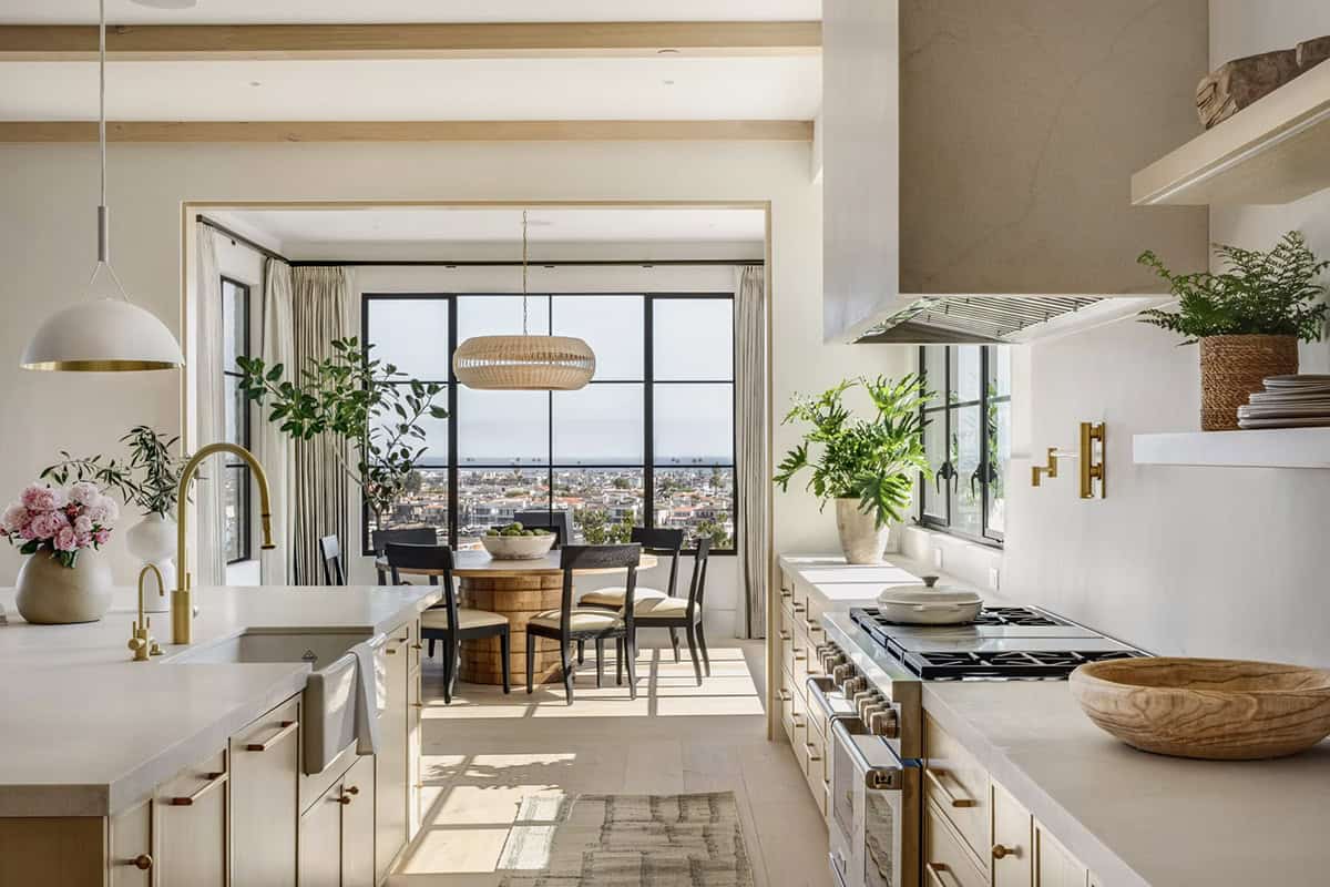Kitchen with farmhouse sink, brass faucet, professional range, and breakfast nook with coastal views