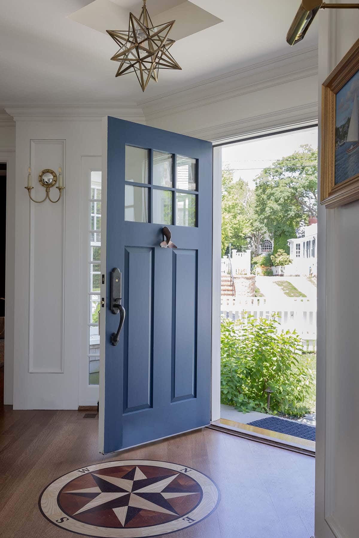 Navy blue front door with compass rose wood inlay floor and Moravian star pendant