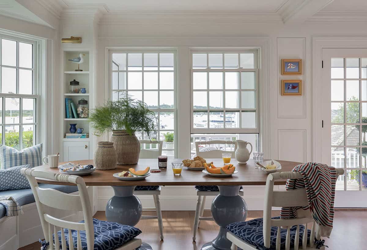 Bright breakfast nook with harbor views, built-in bench and navy pedestal table