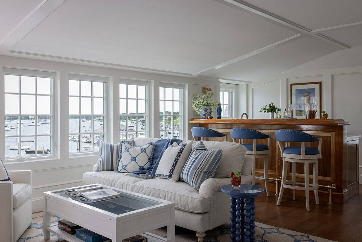 Living room with harbor views, neutral sofa and built-in wet bar with wood paneling