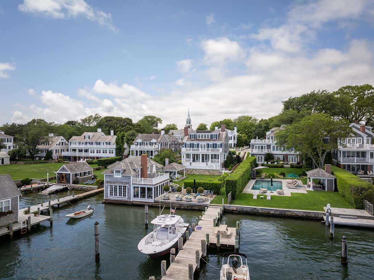 Aerial view of colonial revival estate with pool, private dock and harbor beyond