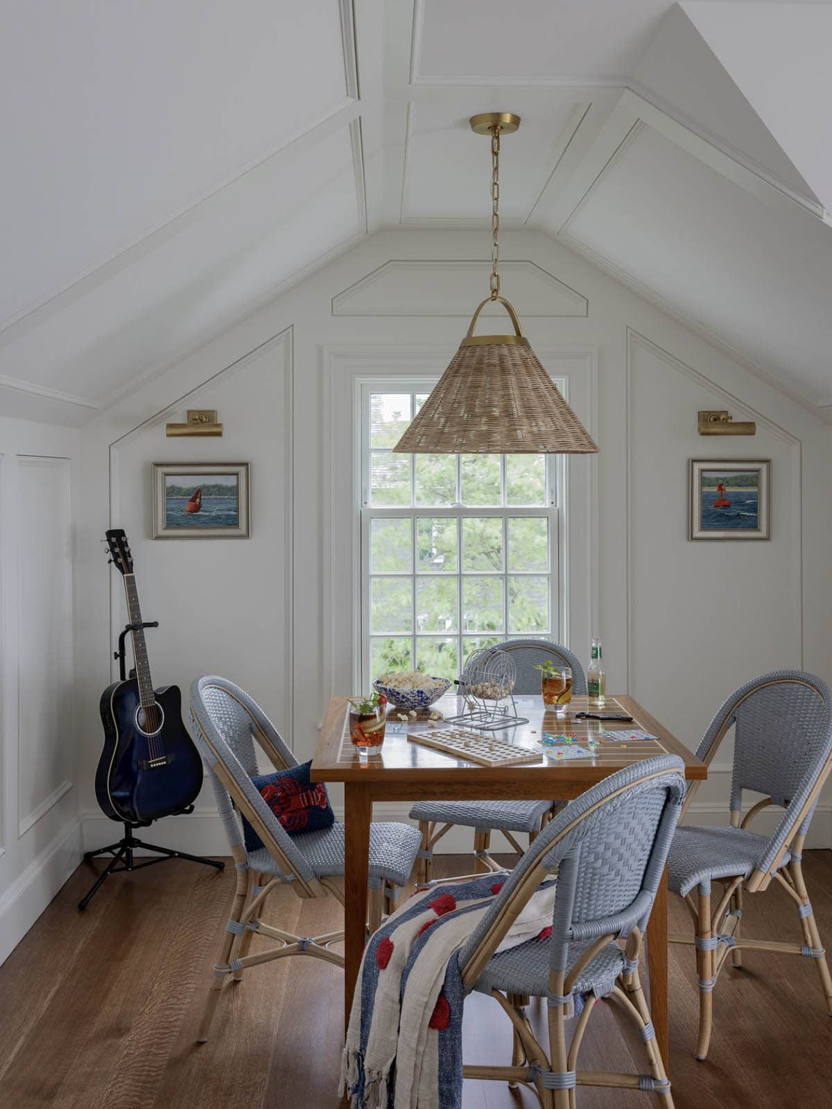 Attic game room with vaulted ceiling, rattan pendant light, bistro chairs and guitar