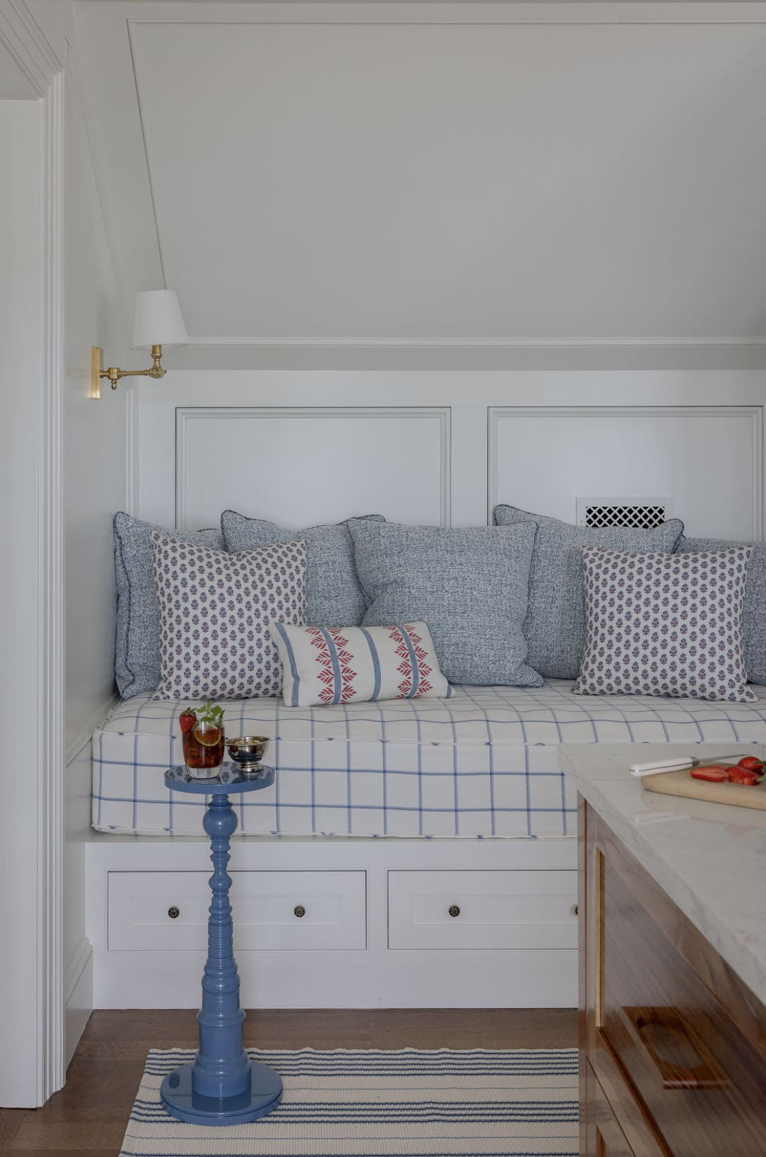 Built-in daybed nook with blue plaid cushion, block print pillows and under-seat storage