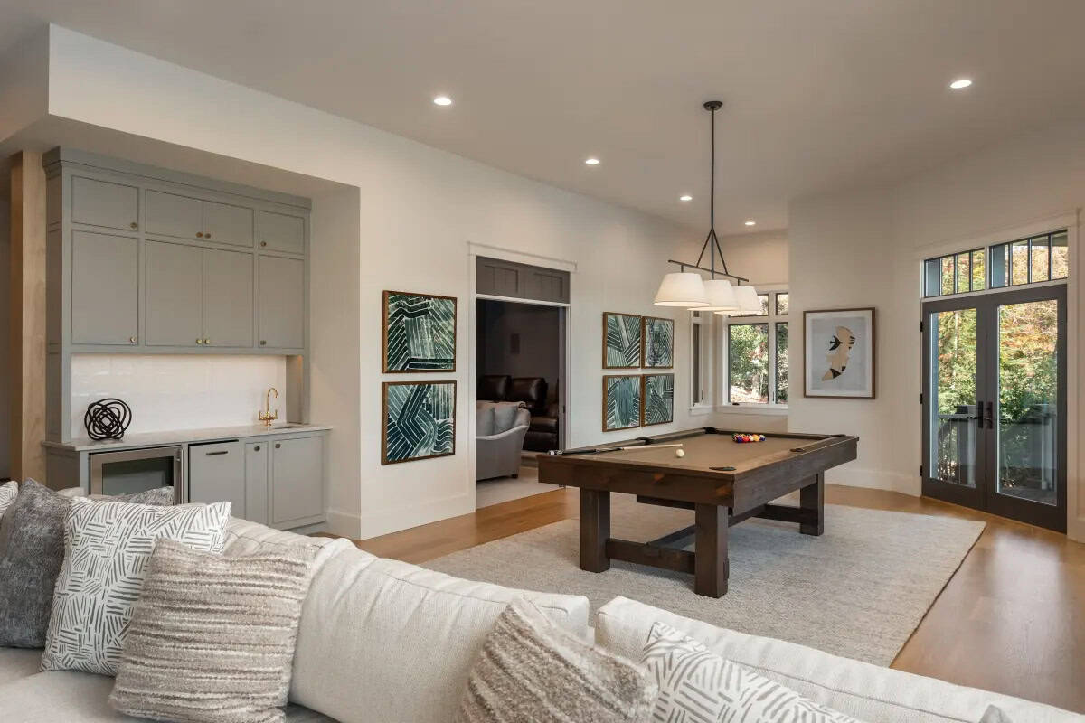 Lower level game room with pool table, gray wet bar, botanical artwork, and view into dark study