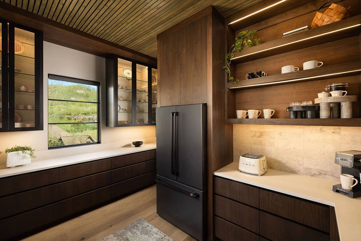 Butler's pantry with dark walnut cabinetry, illuminated open shelving, black Caf&eacute; refrigerator, and coffee bar with Smeg toaster