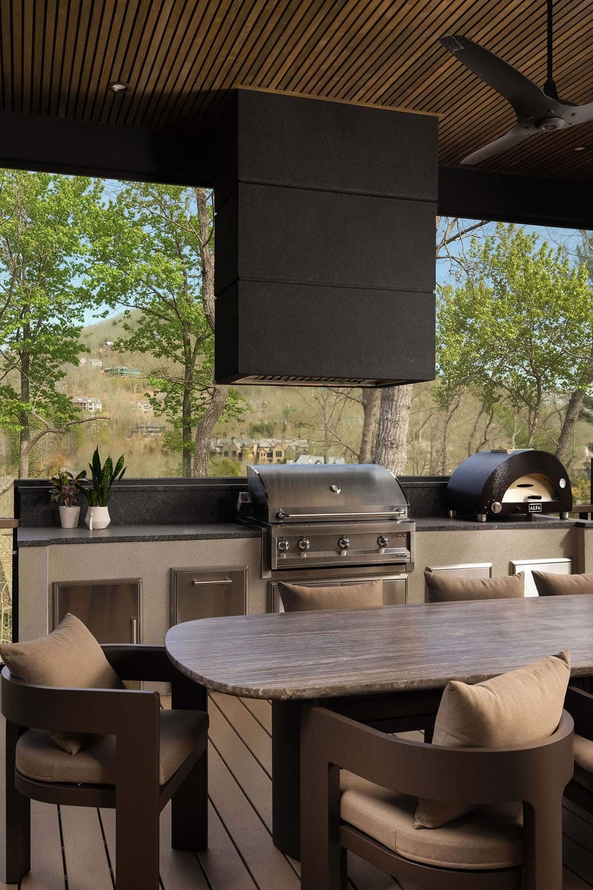 Covered outdoor kitchen with stainless grill, Alfa pizza oven, stone countertops, and mountain views through open screened porch