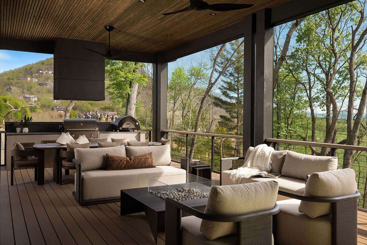 Screened outdoor living deck with neutral sofas, fire pit table, outdoor kitchen, and sweeping Western North Carolina mountain views