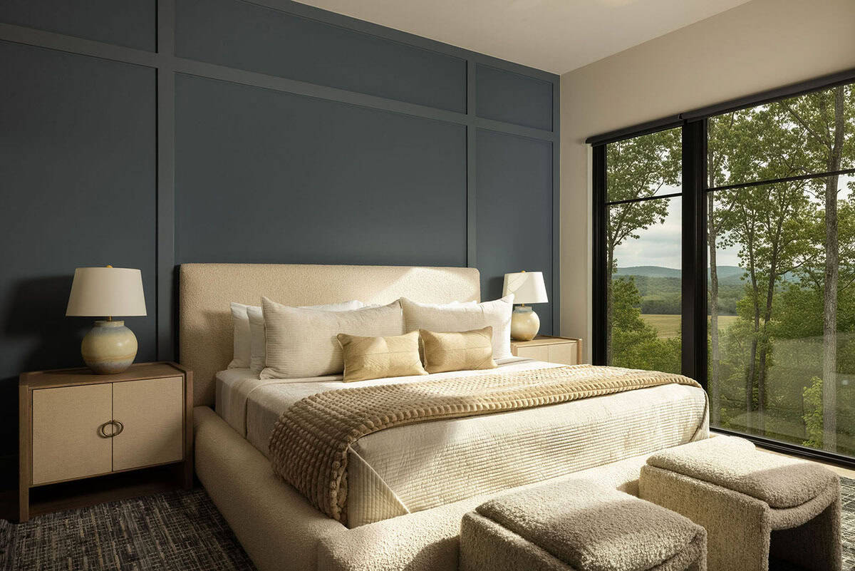 Cozy bedroom with upholstered bed, blue paneled wall, and mountain view window