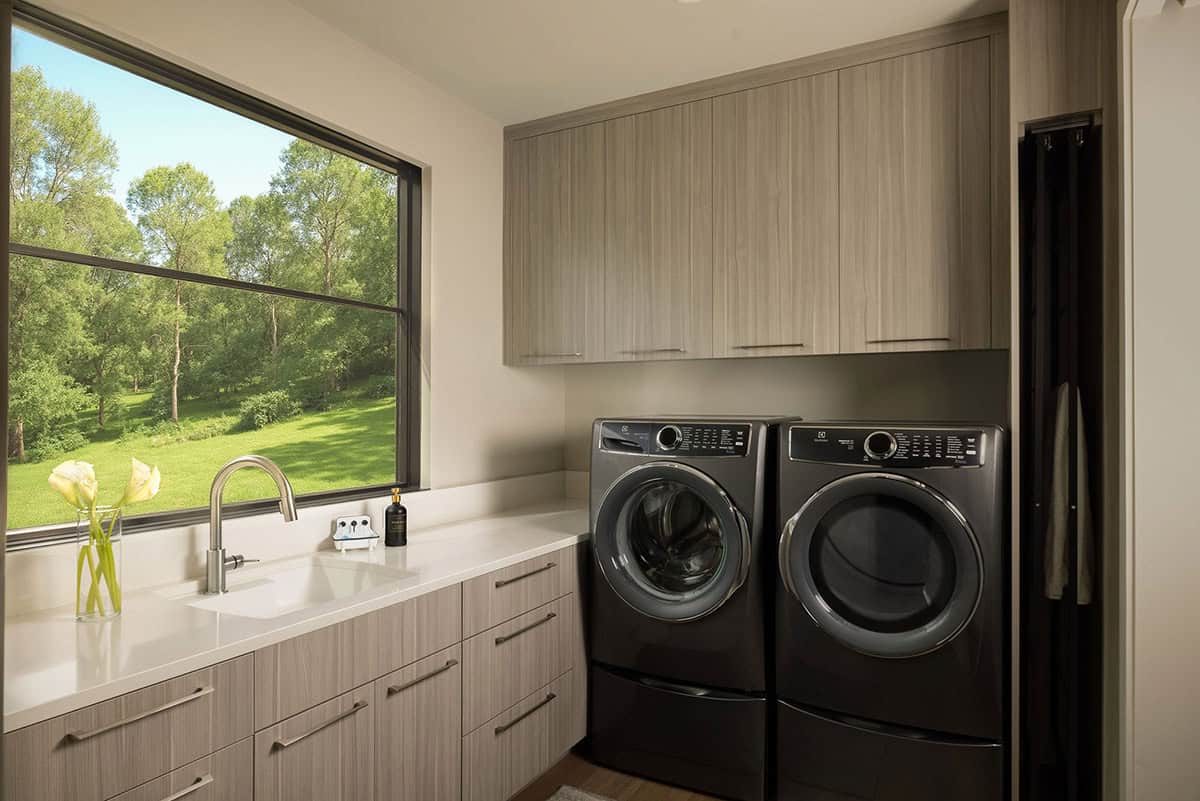 laundry room, Electrolux washer dryer, gray cabinetry, quartz countertop, oversized window