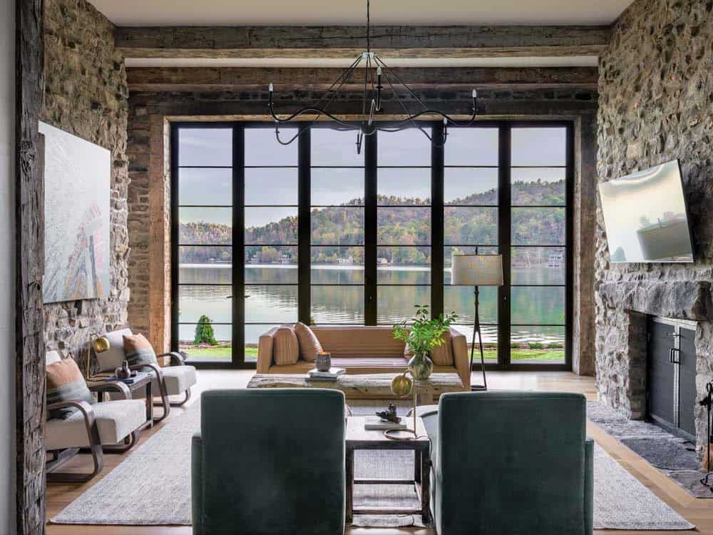 Living room with stone walls, steel-frame picture windows, and lake views