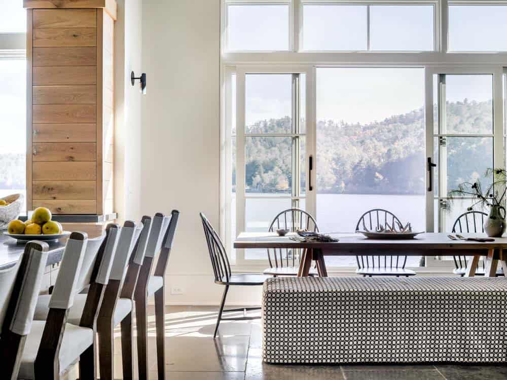Bright dining area with Windsor chairs and large casement windows overlooking the lake