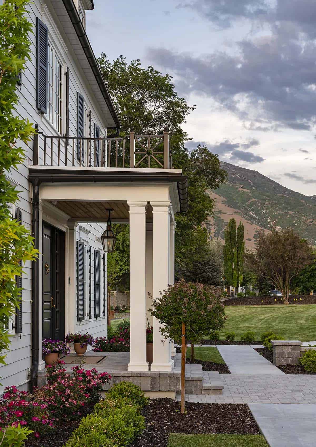 Covered side porch with columns, gas lantern, and mountain backdrop