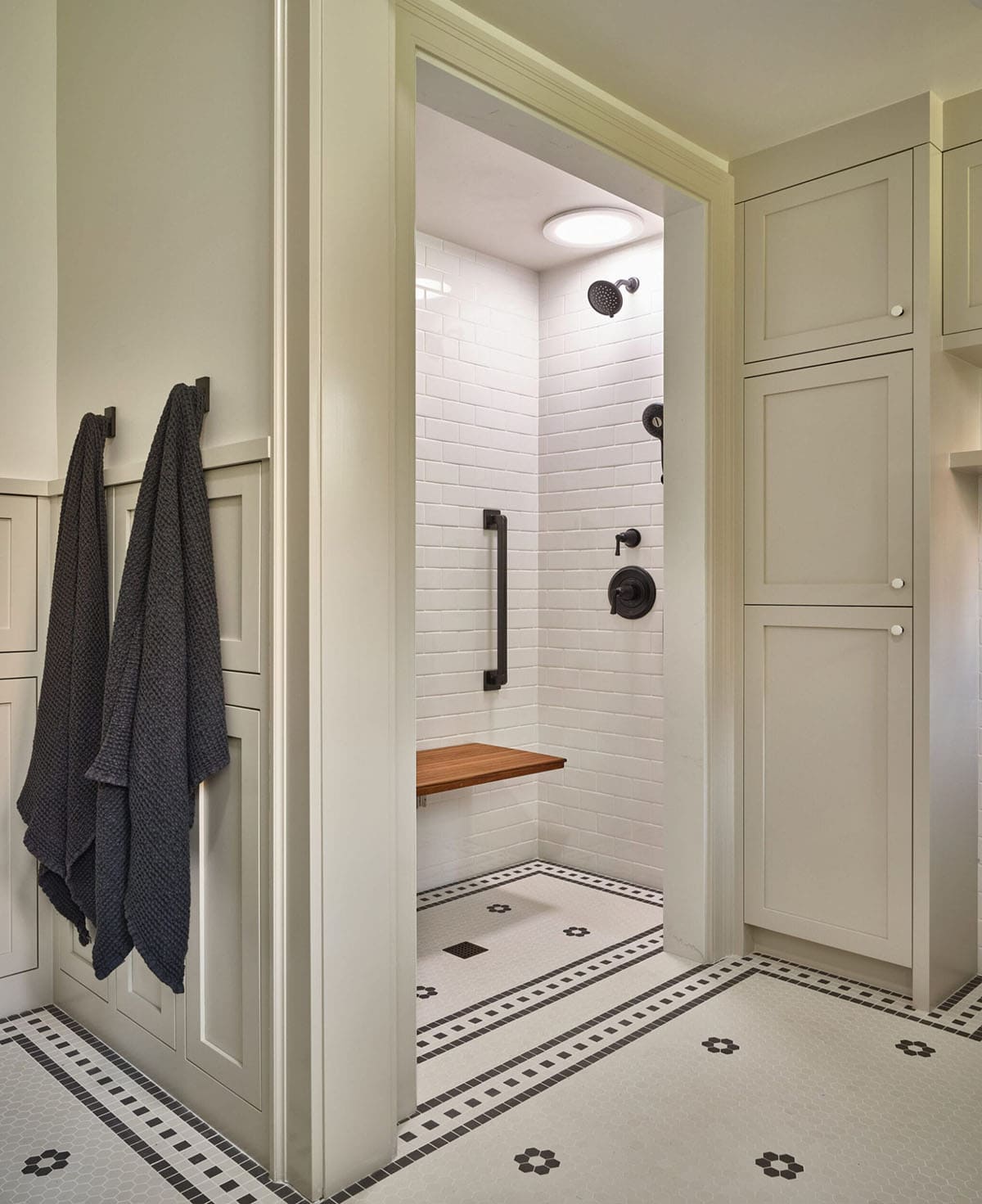 Bathroom with walk-in shower with white subway tiles and mosaic flooring