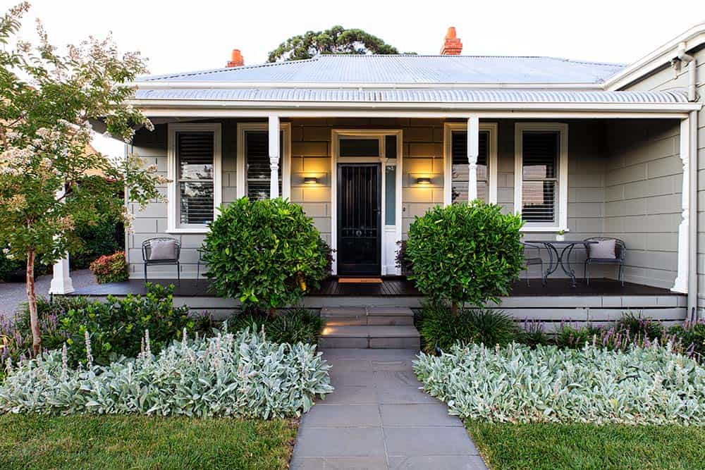Small front yard with Natchez crepe myrtle, lavender border, and classic porch on gray cottage-style home