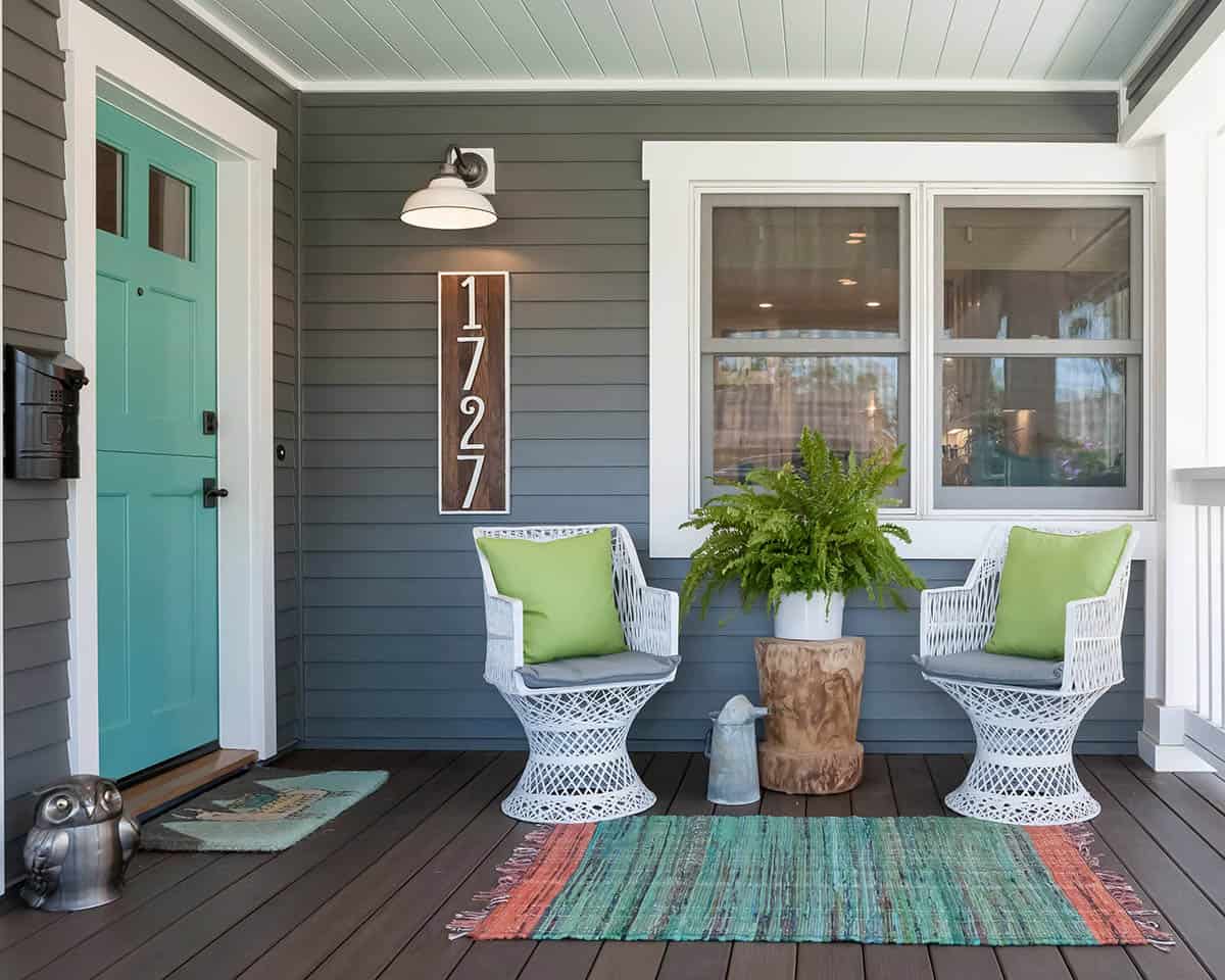 Grey Porch With Turquoise Door, White Wicker Chairs, and Haint Blue Ceiling
