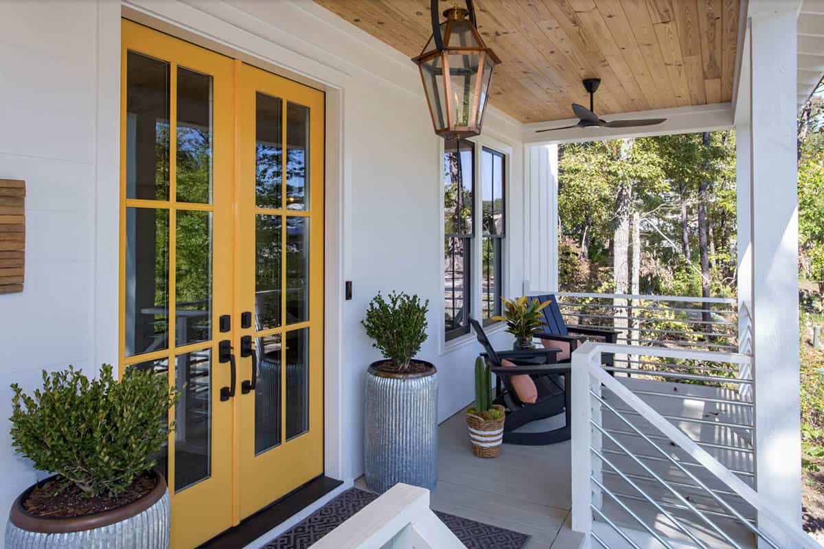 White Farmhouse Porch With Bold Yellow French Doors and Copper Lantern