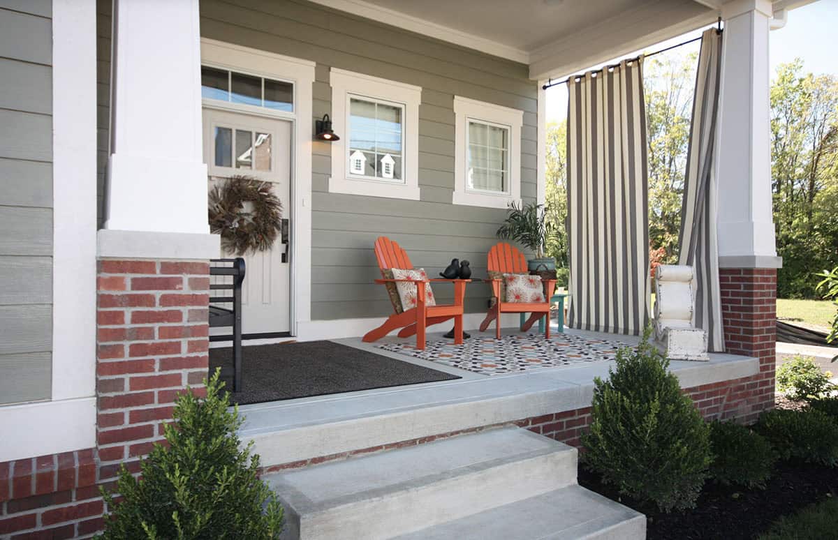 Grey Craftsman Porch With Orange Adirondack Chairs and Striped Outdoor Curtains