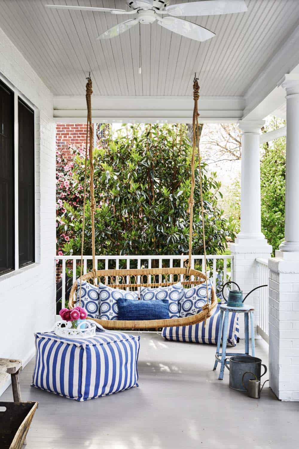 White Porch With Rattan Rope Swing, Blue Striped Pouf, and Ceiling Fan