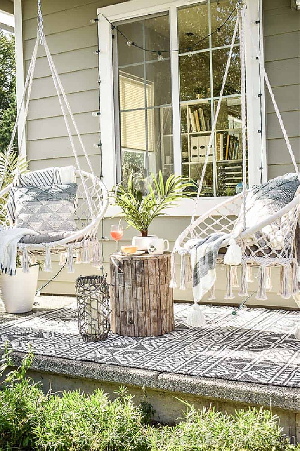Alt tag: Boho Porch With Two Macrame Hanging Chairs, Stump Table, and String Lights