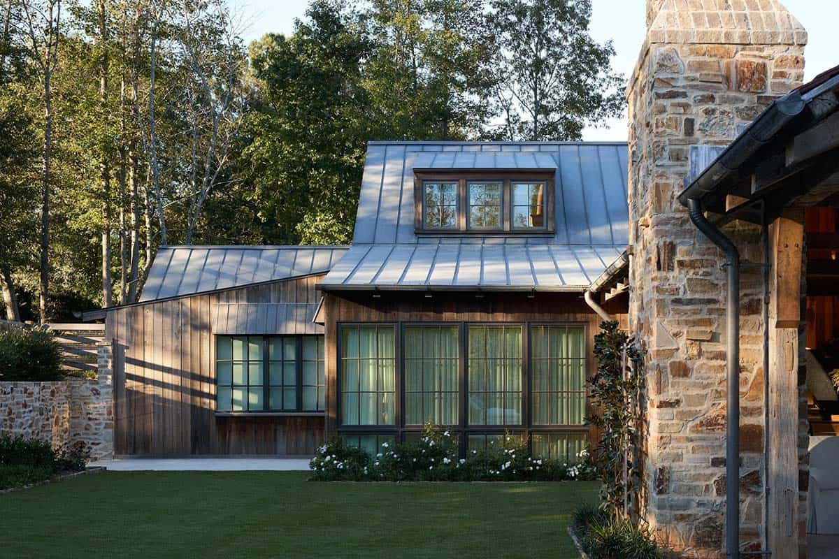Reclaimed wood barn wing with metal mansard roof, dormer window, and steel casement windows