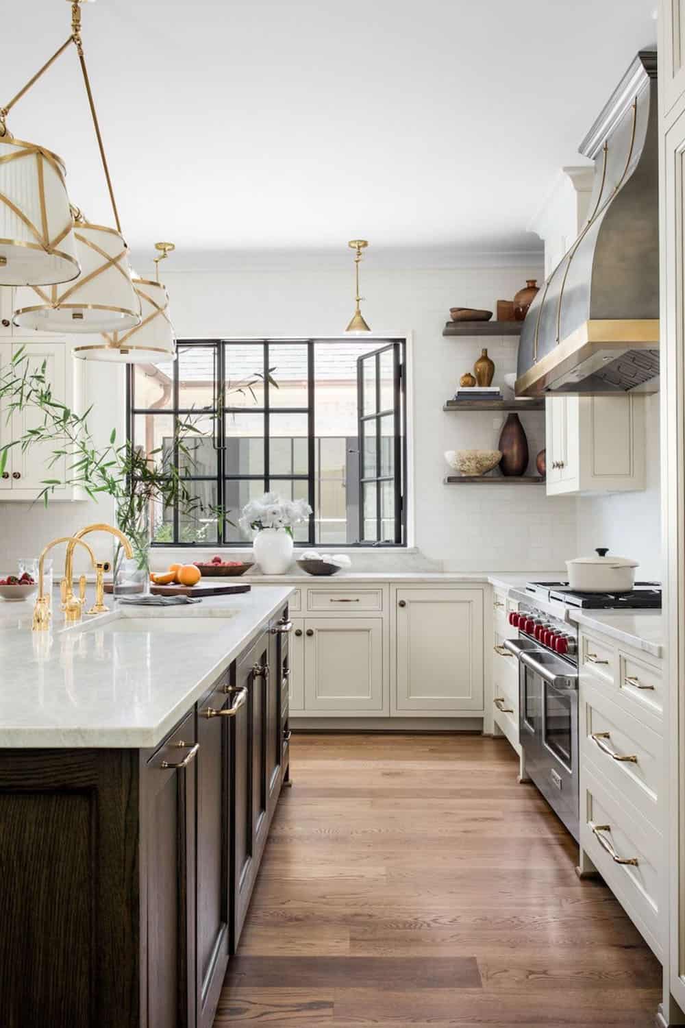 Kitchen view with black-framed windows, marble countertops, and stainless range with brass accents