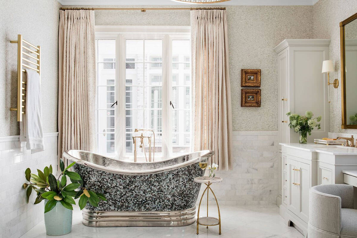 Luxurious primary bathroom with mosaic freestanding soaking tub and marble floors