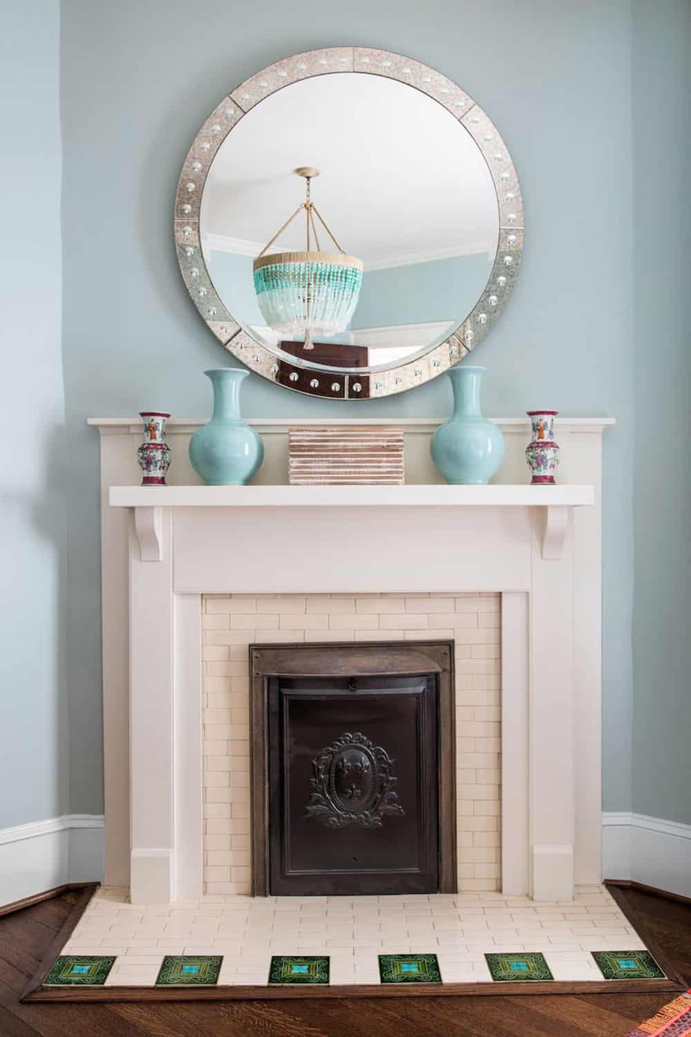 Bedroom fireplace mantel with round mosaic mirror and celadon ceramic vases